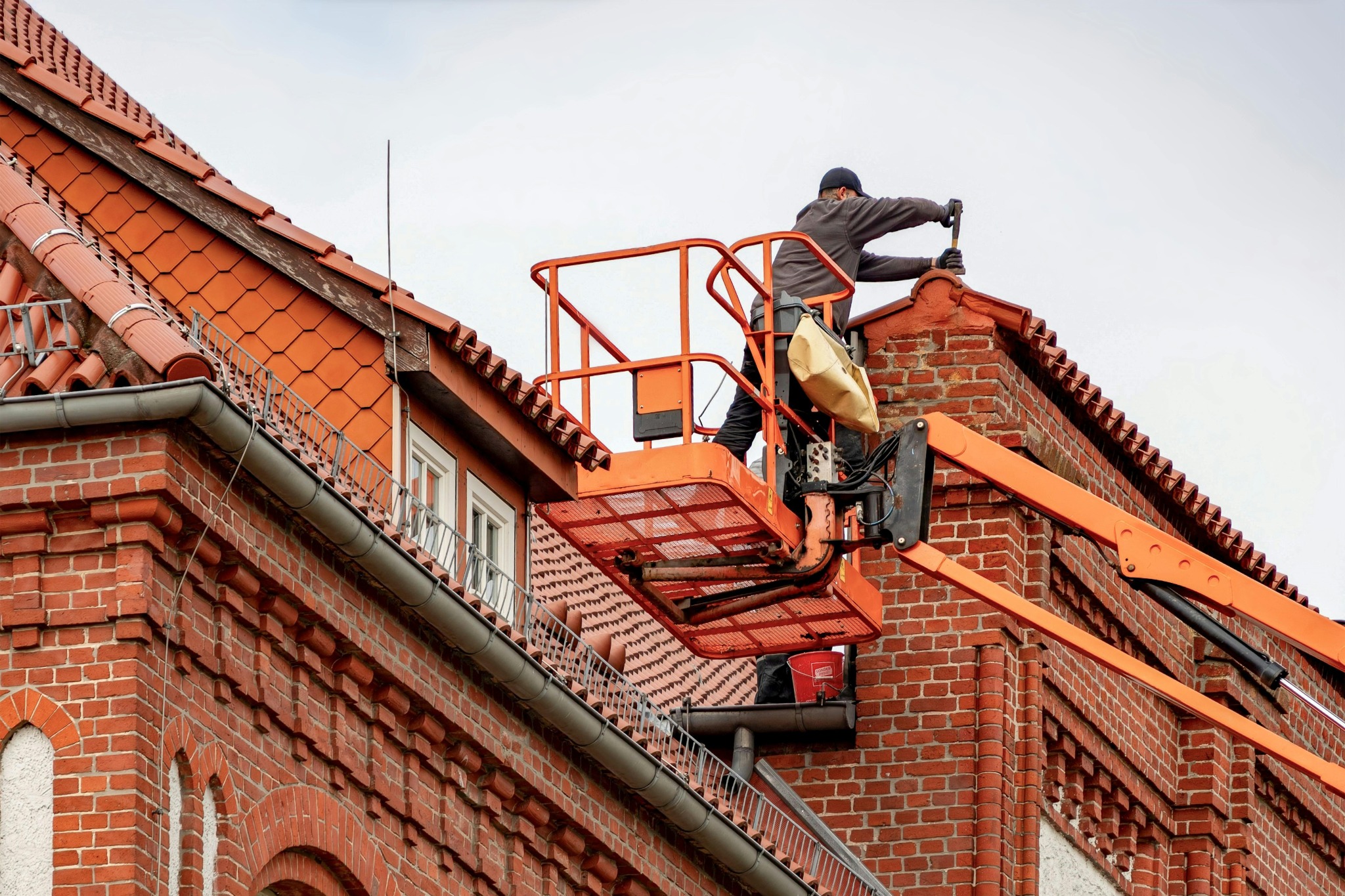 Roofer working near chimney from lift