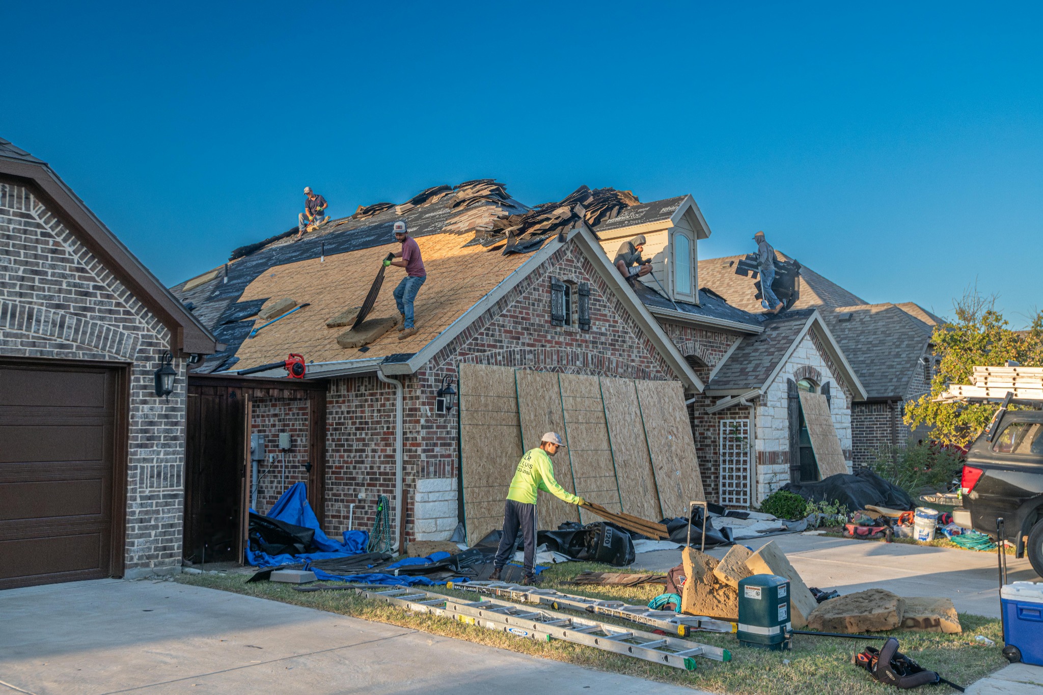 Roofing crew repairing storm damaged roof
