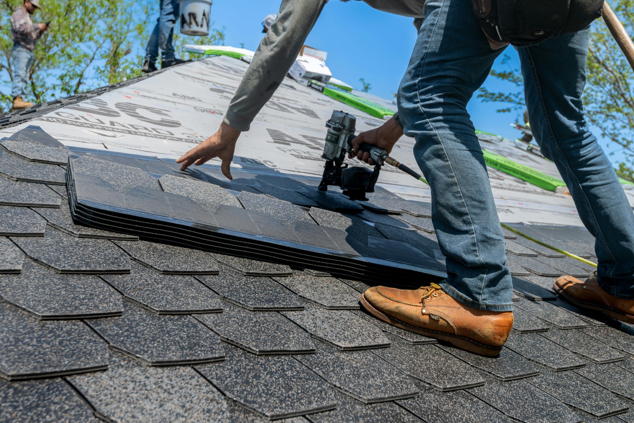Roofer repairing shingles to stop a roof leak