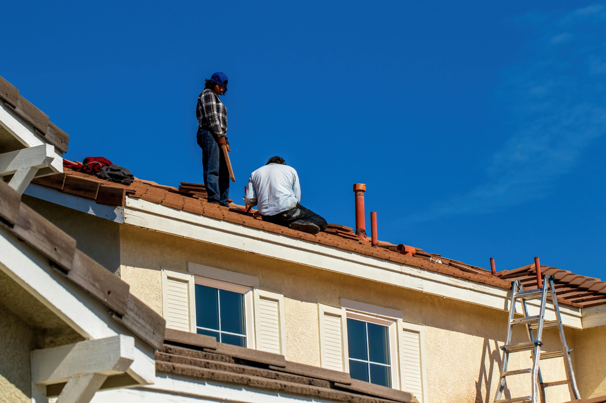 Roofers working on storm damaged residential roof